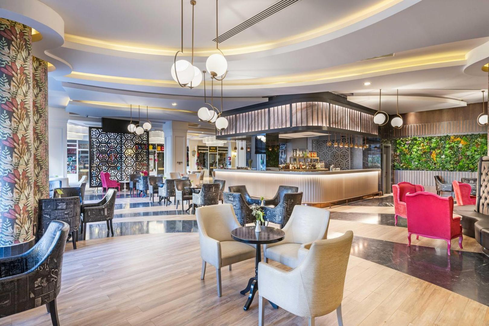 Kirman Hotels Belazur Resort & Spa lobby bārs ar modernām mēbelēm, stilīgu apgaismojumu un mājīgu atpūtas zonu viesiem.
