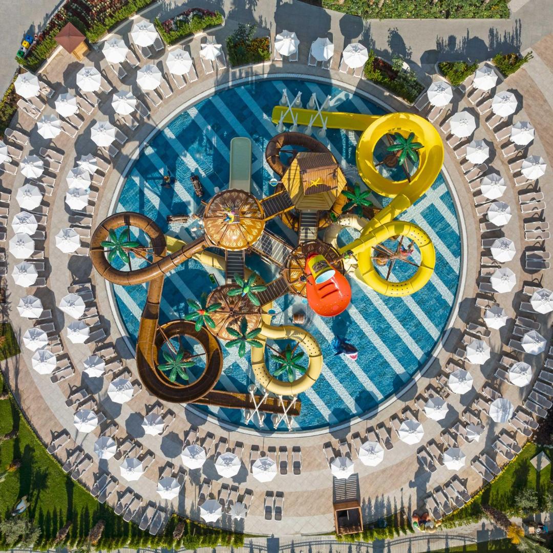 Kirman Hotels Belazur Resort & Spa bērnu baseina un akvaparka skats no augšas ar saulessargiem un atpūtas zonu Belekā