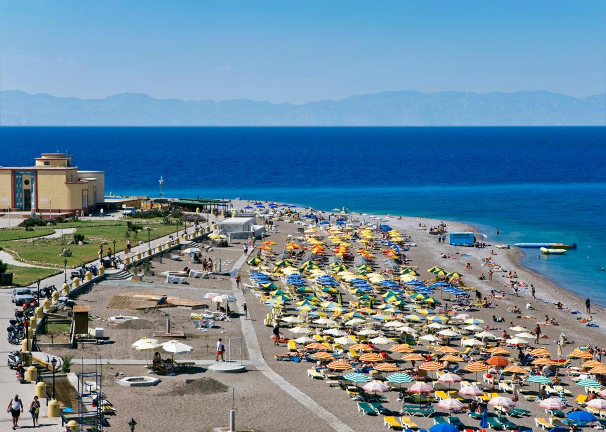 Skats no augšas uz Mediterranean Hotel pludmales zonu ar krāsainiem saulessargiem un atpūtas krēsliem Rodas piekrastē, Grieķijā