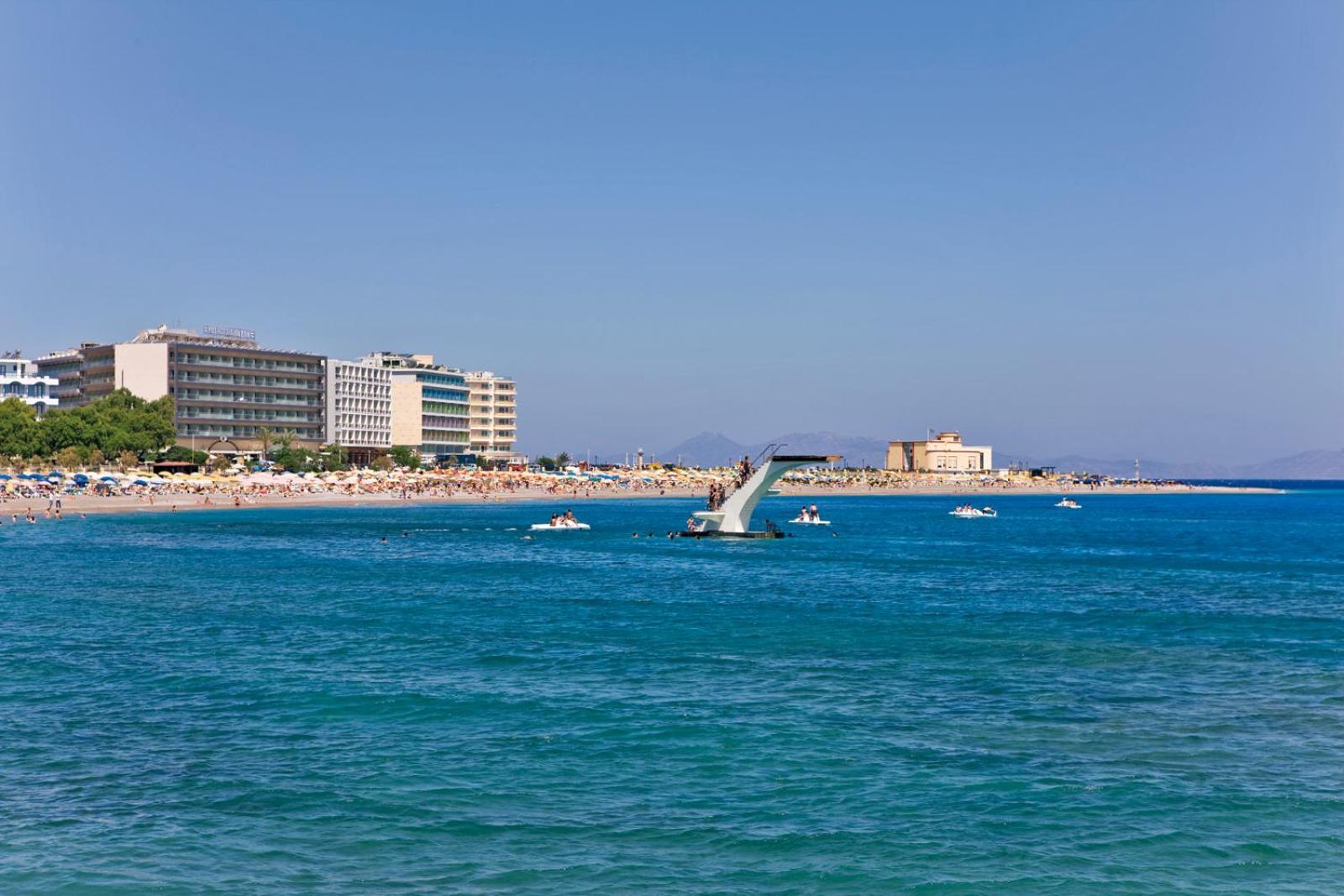 Skats no jūras uz Mediterranean Hotel ēku un Rodas pilsētas pludmali ar slaveno tramplīnu ūdenī