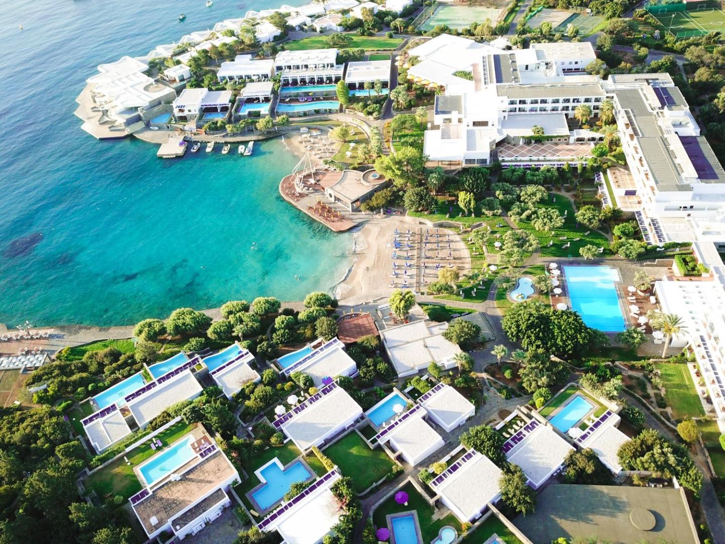 Elounda Bay Palace Hotel plašā teritorija ar dārziem, baseiniem un bungalo tipa numuriem pie Vidusjūras līča Krētā.