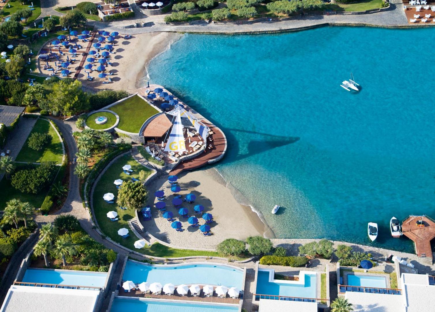 Elounda Bay Palace Hotel piekrastes zona ar pludmales bāru, saulessargiem un numuriem ar tiešu piekļuvi baseinam Krētas salā.