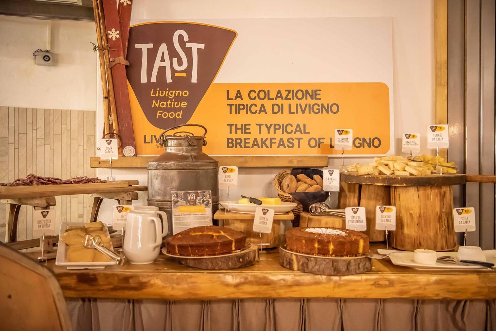 Tradicionālo Livinjo produktu galds viesnīcā Alpen Resort Bivio ar kūkām, sieriem un vietējiem gardumiem 'Tast' koncepta ietvaros