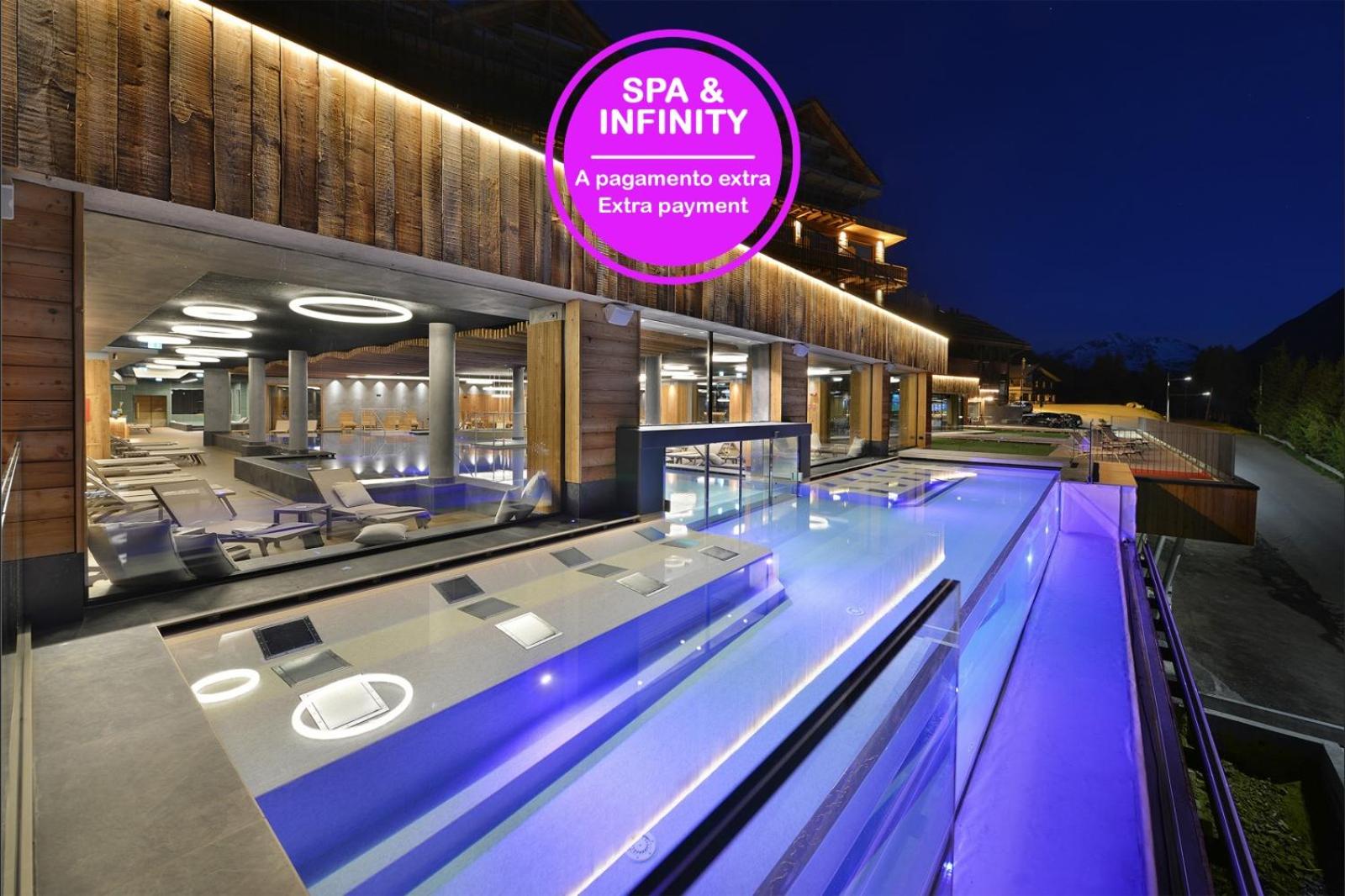 Alpen Resort Bivio spa centrs vakarā ar izgaismotu baseinu, atpūtas krēsliem un modernu interjeru Livinjo, Itālijā