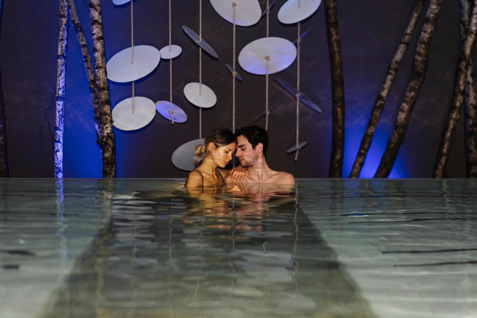 Pāris bauda relaksāciju Lac Salin Spa & Mountain Resort spa centrā ar romantisku apgaismojumu un dabas elementu dekorācijām