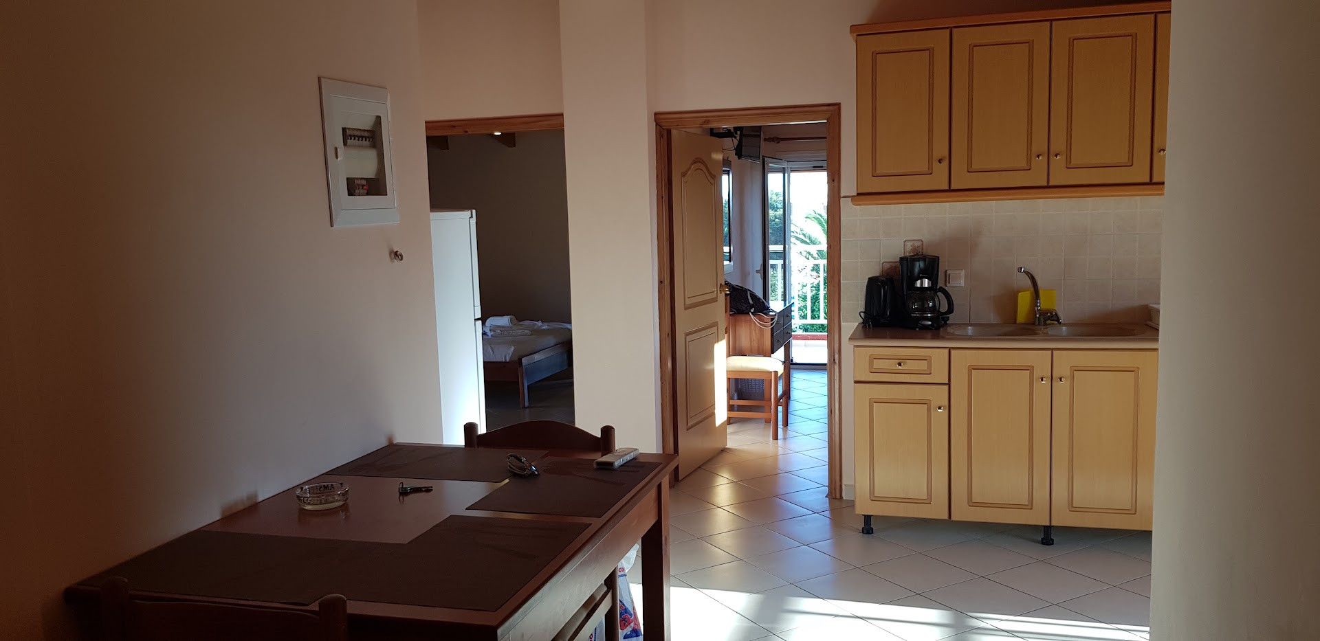 Brati Arkoudi Hotel apartamentu virtuves zona ar koka skapīšiem, kafijas aparātu un ēdamgaldu Peloponēsas piekrastē.