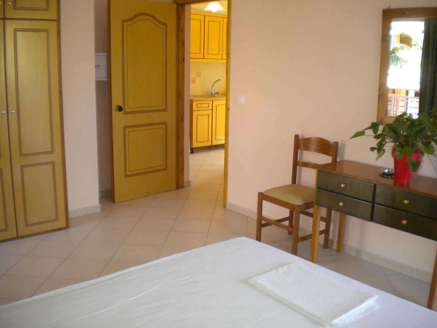 Brati Arkoudi Hotel studijas tipa numurs ar skatu uz virtuves zonu, koka mēbelēm un gaišu flīžu grīdu Peloponēsas reģionā.