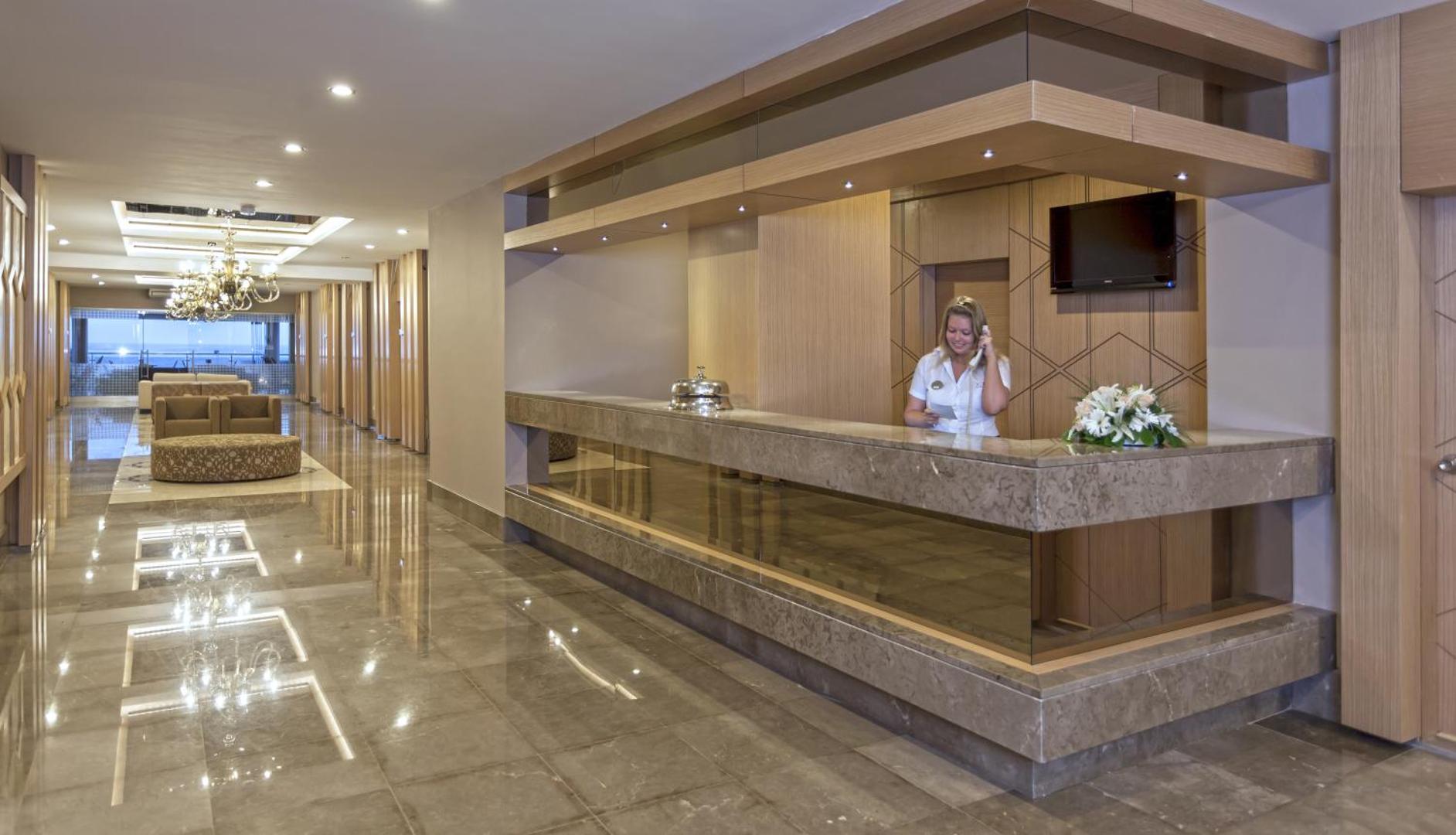 Xperia Saray Beach viesnīcas recepcijas zona ar marmora apdari, modernu apgaismojumu un viesmīlīgu personālu Alanjas kūrortā