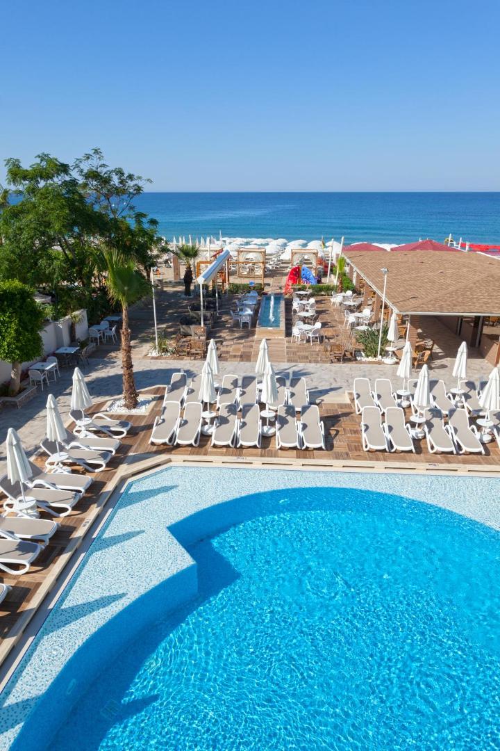 Skats no Xperia Saray Beach terases uz baseinu, pludmales bāru un zilo Vidusjūru Alānijas piekrastē