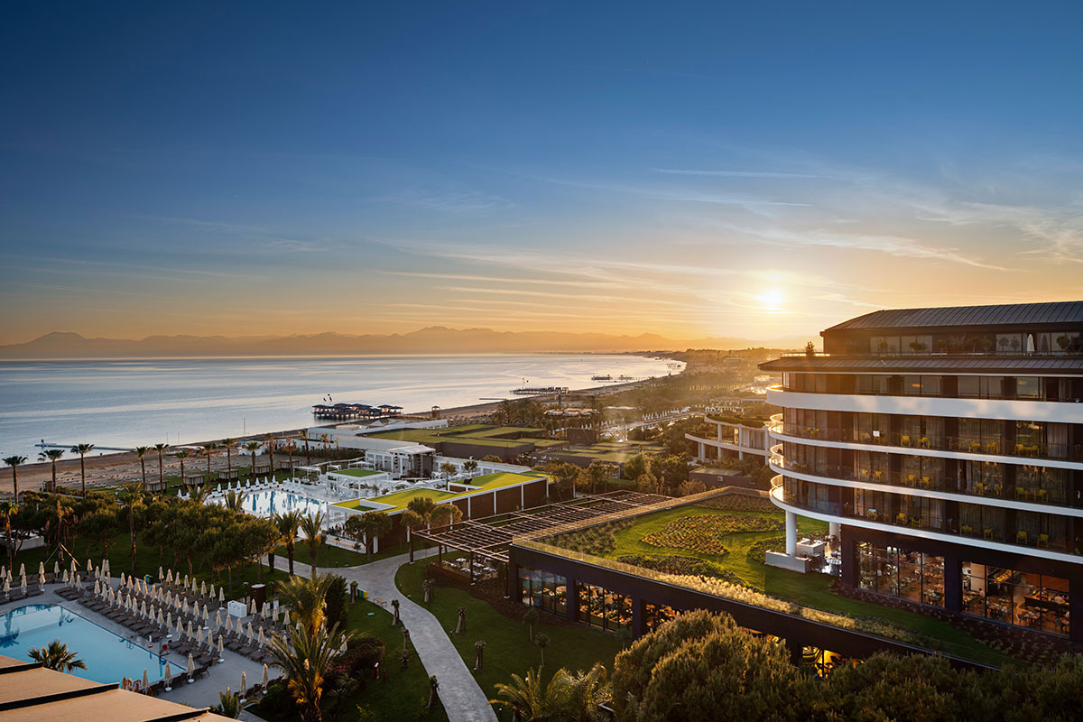 Panorāmas skats uz Voyage Belek Golf & Spa teritoriju, pludmali un Vidusjūru saulrieta laikā Belekā