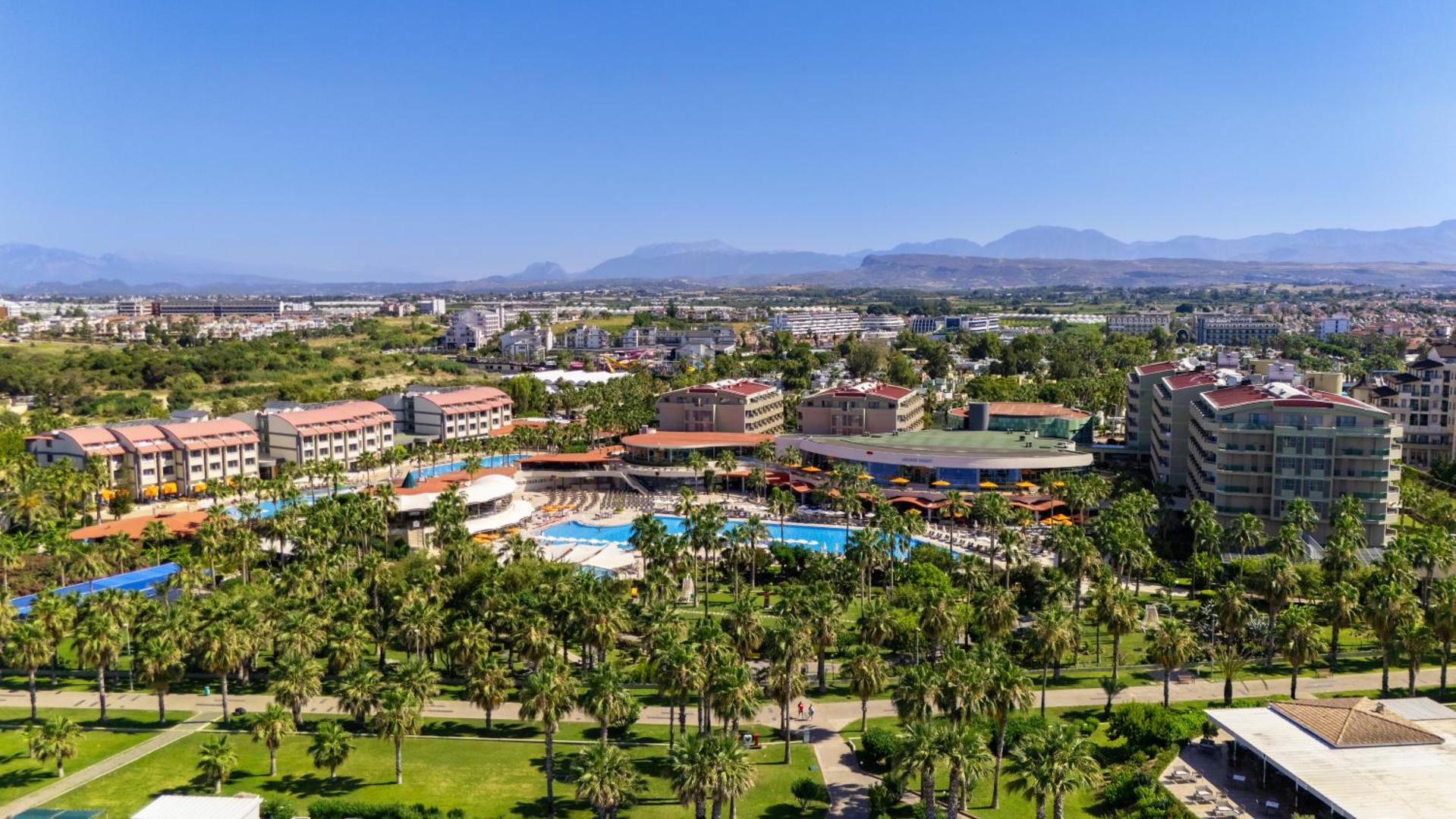 Von Resort Golden Coast viesnīcas panorāma ar baseiniem, palmu dārzu un kalniem fonā