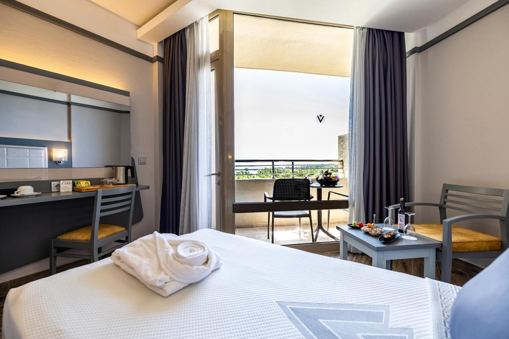 VONRESORT Golden Coast gaišs numurs ar balkonu, rakstāmgaldu un atpūtas zonu — skats uz balkona mēbelēm un dabu Side piekrastē
