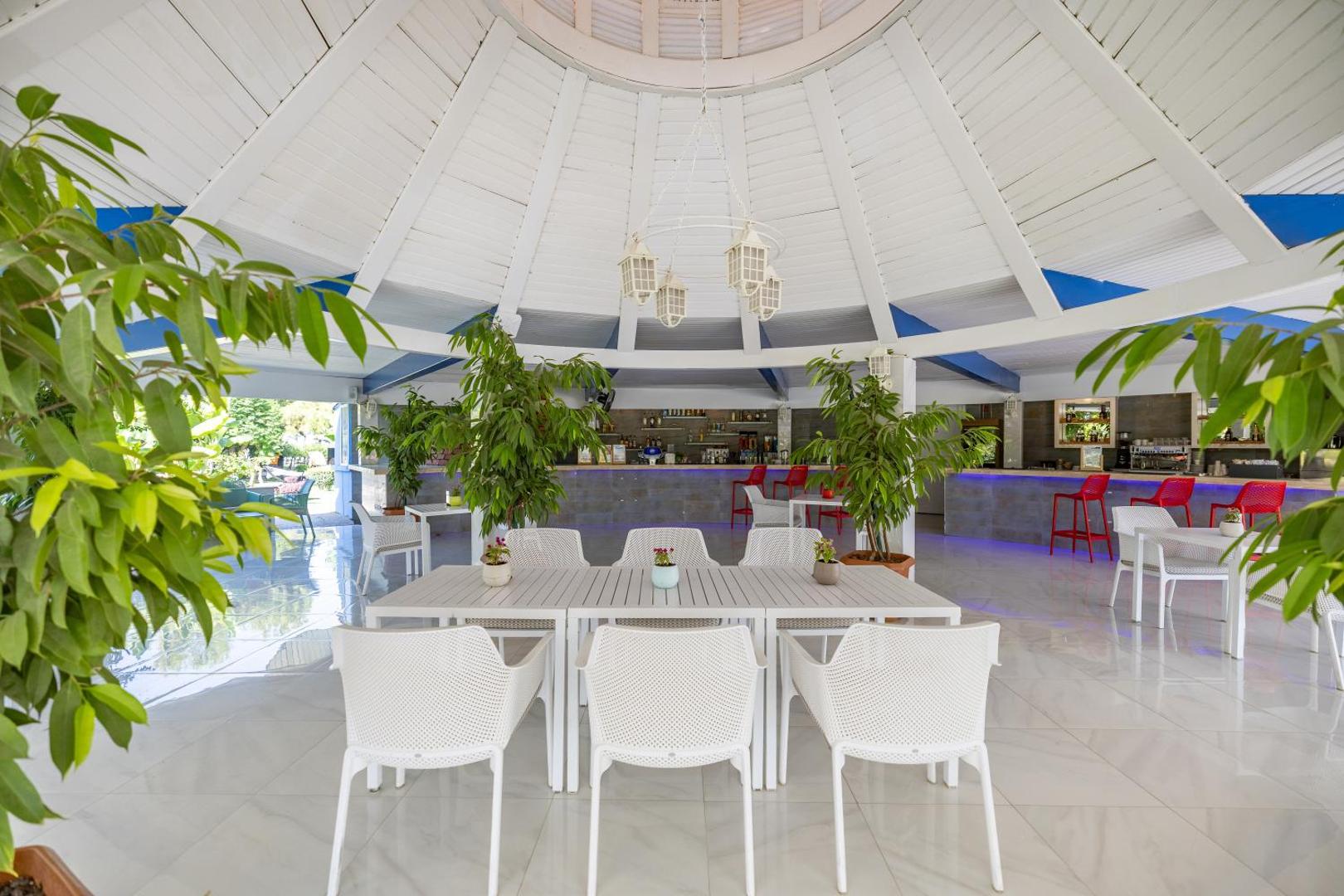 Viesnīcas Vonresort Elite gaišais lobby bārs ar modernām mēbelēm, telpaugiem un kupolveida griestiem Antaljas reģionā, Turcijā
