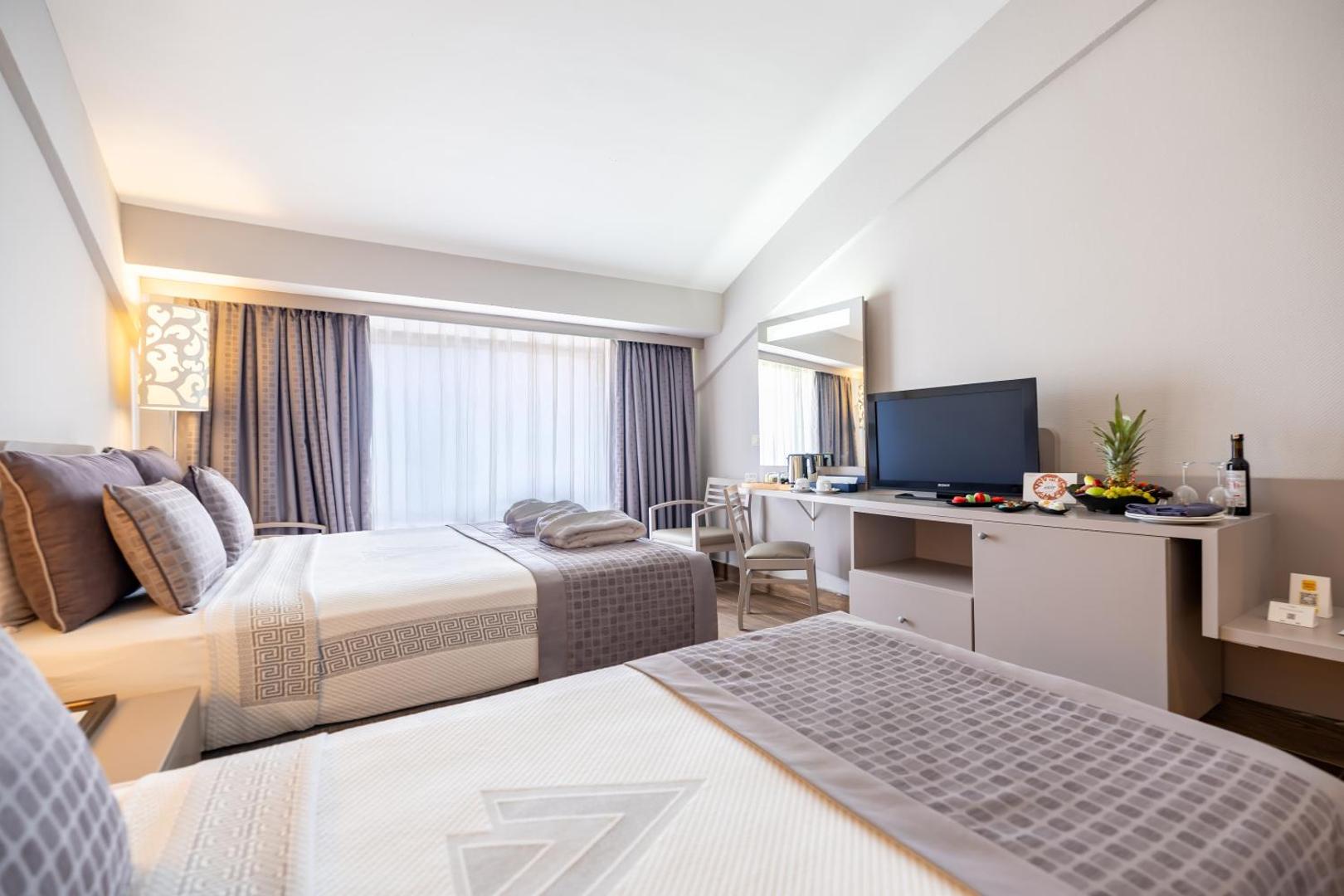 Vonresort Elite viesnīcas numurs ar divām atsevišķām gultām, televizoru un lielu logu Side kūrortā