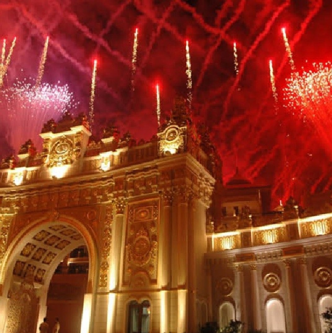 Svētku uguņošana virs Titanic Mardan Palace greznajiem vārtiem un fasādes nakts laikā Antālijā