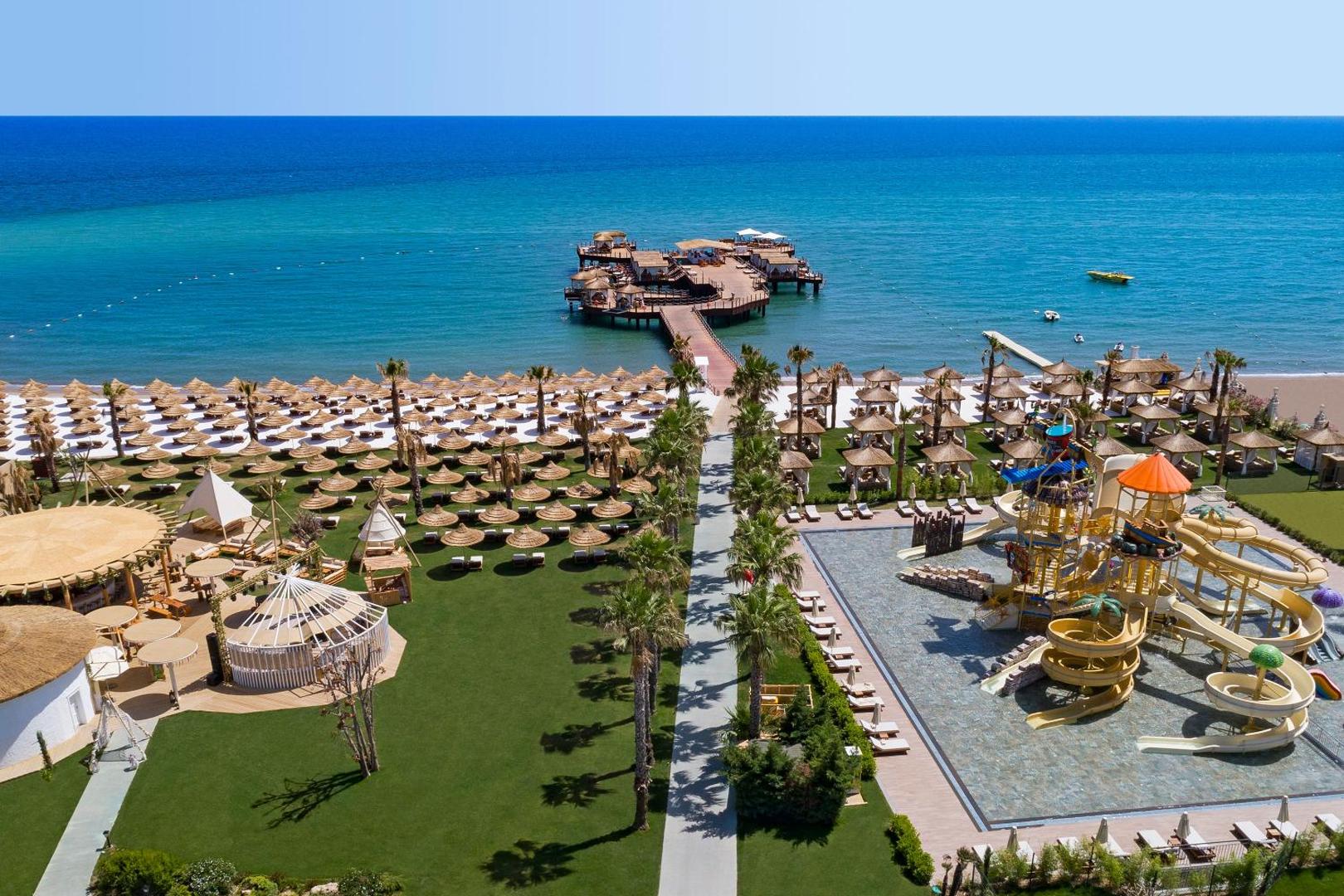 Titanic Mardan Palace skats no augšas uz privāto pludmali, koka piestātni, bērnu ūdens atrakciju parku un tirkīza jūru