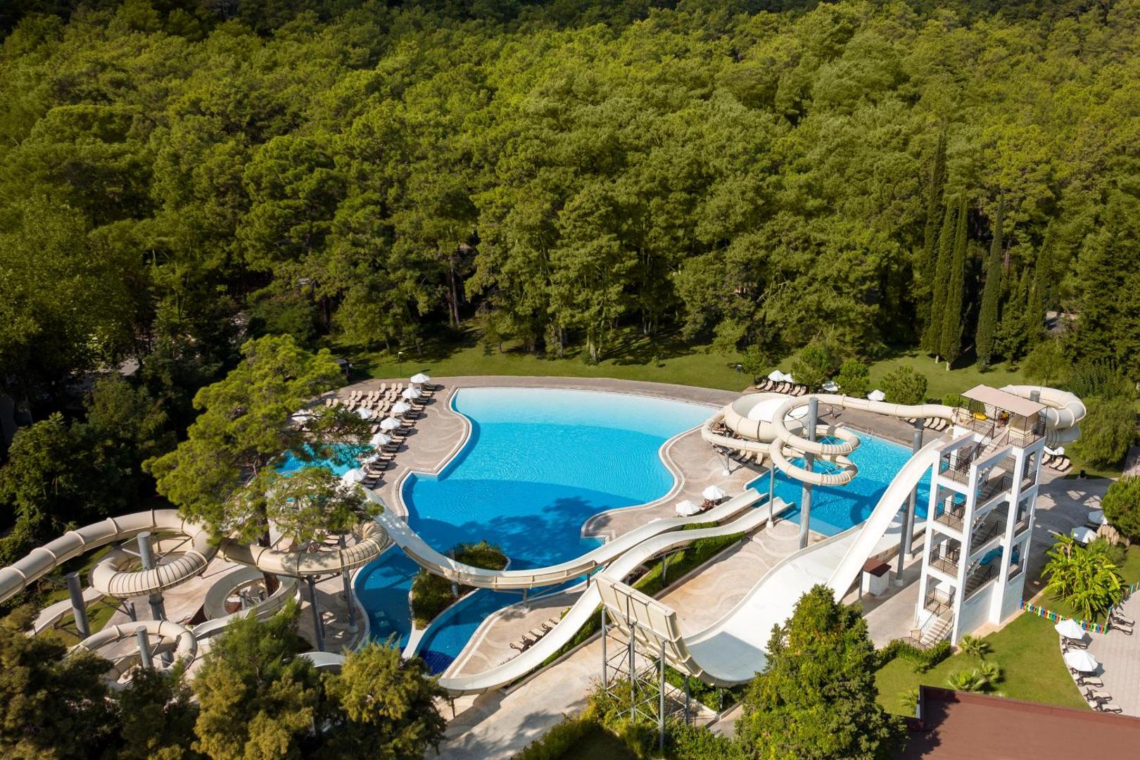 Sherwood Exclusive Kemer akvaparks ar vairākiem ūdens slidkalniņiem un lielu baseinu priežu meža ieskautā teritorijā Kemeras reģionā, Turcijā