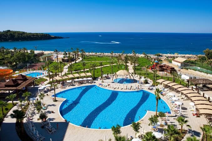 Saphir Resort & Spa teritorijas skats no augšas ar baseiniem, dārzu un privāto pludmali pie dzidri zilās jūras