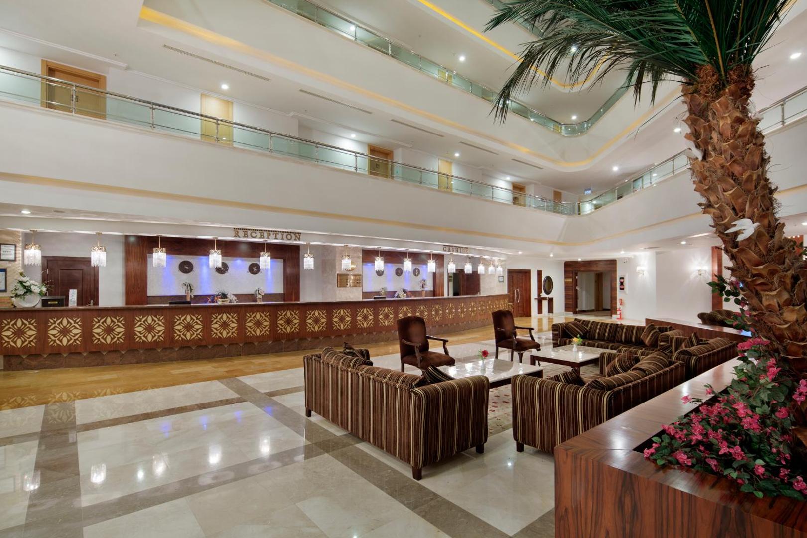 Viesnīcas Saphir Resort & Spa recepcijas zona ar koka apdari, mīkstajiem dīvāniem un dekoratīviem elementiem — viesu uzņemšanas telpa