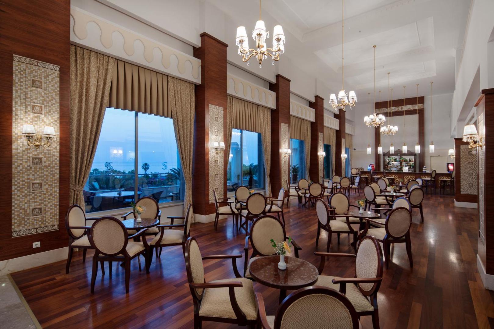 Viesnīcas Saphir Resort & Spa bārs un atpūtas telpa ar klasiskām mēbelēm un skatu uz jūru caur lielajiem logiem