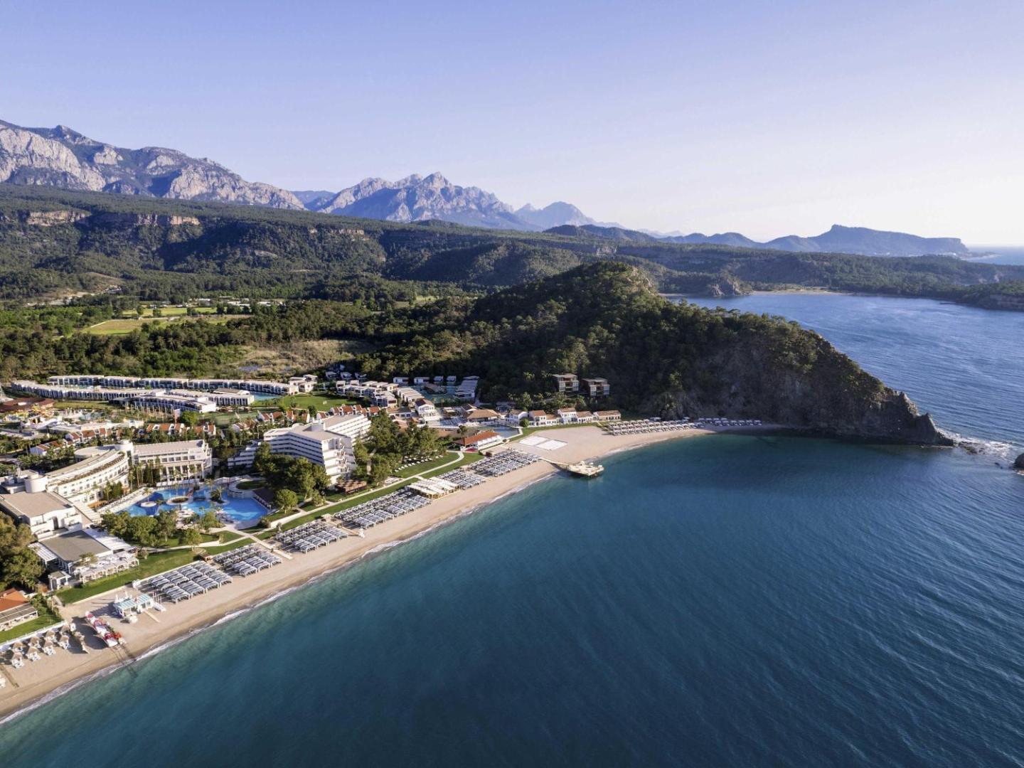 Rixos Premium Tekirova panorāmas skats uz viesnīcas kompleksu, privāto pludmali un kalniem Kemeras reģionā, Turcijā