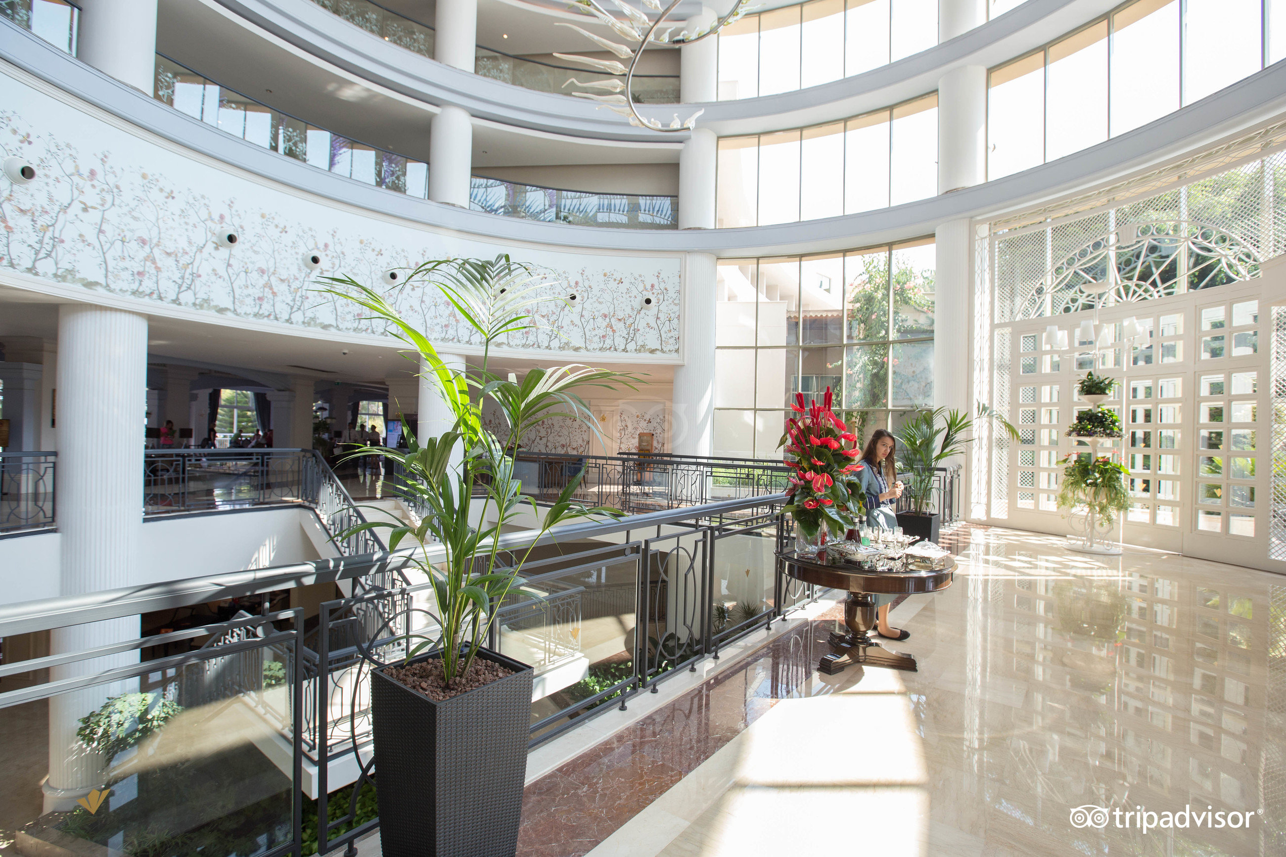 Rixos Premium Tekirova plašais un gaišais vestibils ar augstiem griestiem, dekoratīviem augiem un stiklotām sienām