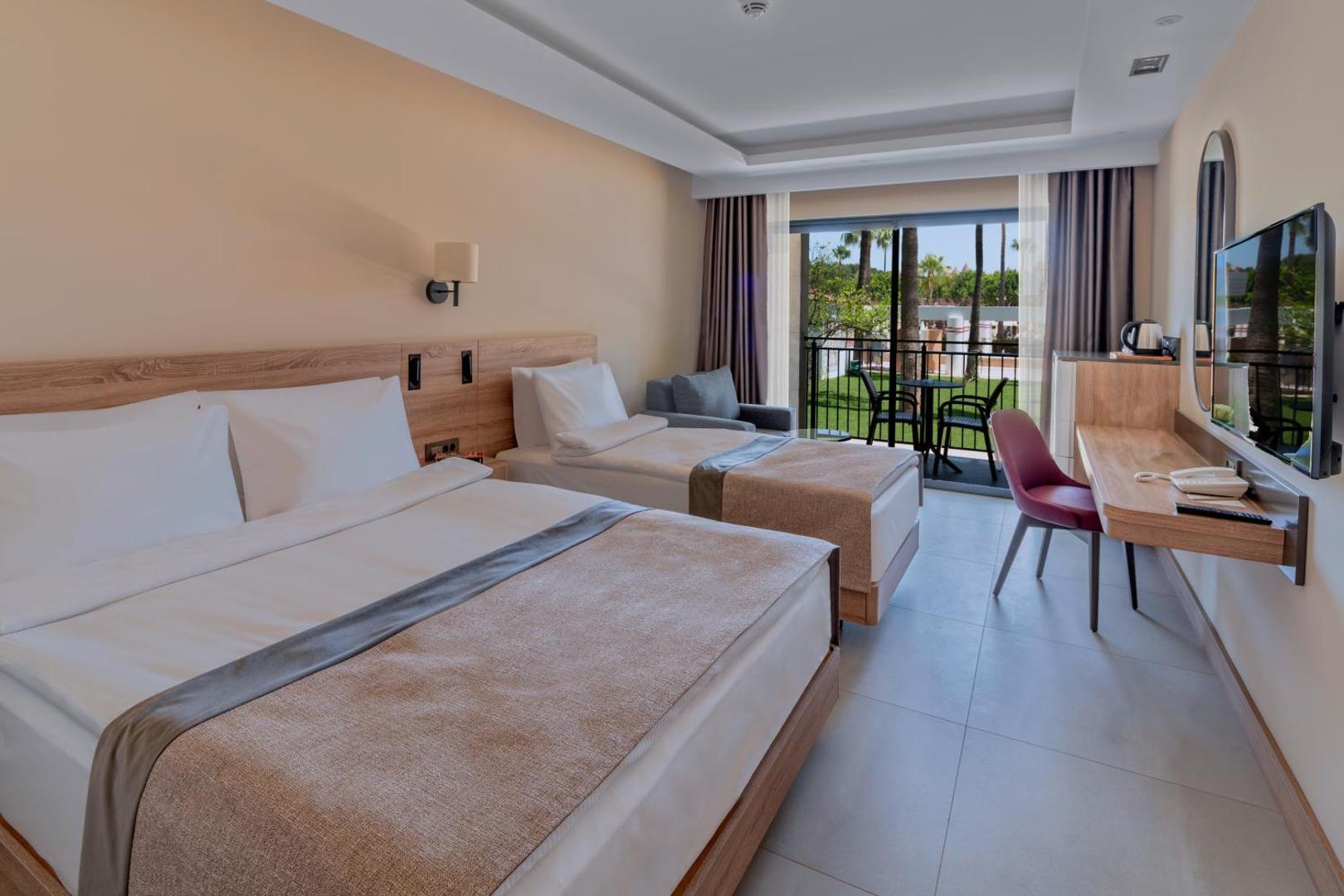 Swandor Hotels & Resorts gaišs standarta numurs ar divguļamo un vienguļamo gultu, balkonu un skatu uz dārzu Antaljas reģionā
