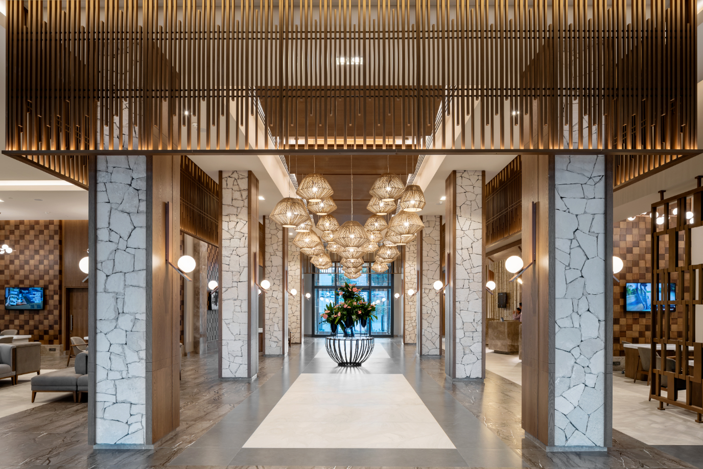 Swandor Hotels & Resorts modernais lobby vestibils ar akmens kolonnām, dizaina lampām un elegantu atpūtas zonu