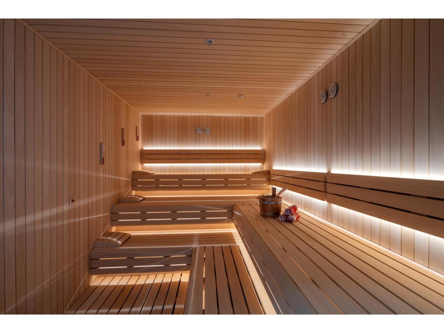 Swandor Hotels & Resorts spa centra sauna ar koka apdari un siltu apgaismojumu — relaksācijas zona viesnīcas viesiem