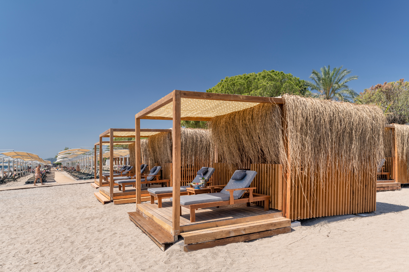 Privātas atpūtas teltis jeb bungalo Swandor Hotels & Resorts smilšu pludmalē ar ērtiem zviļņiem un palmu fonā