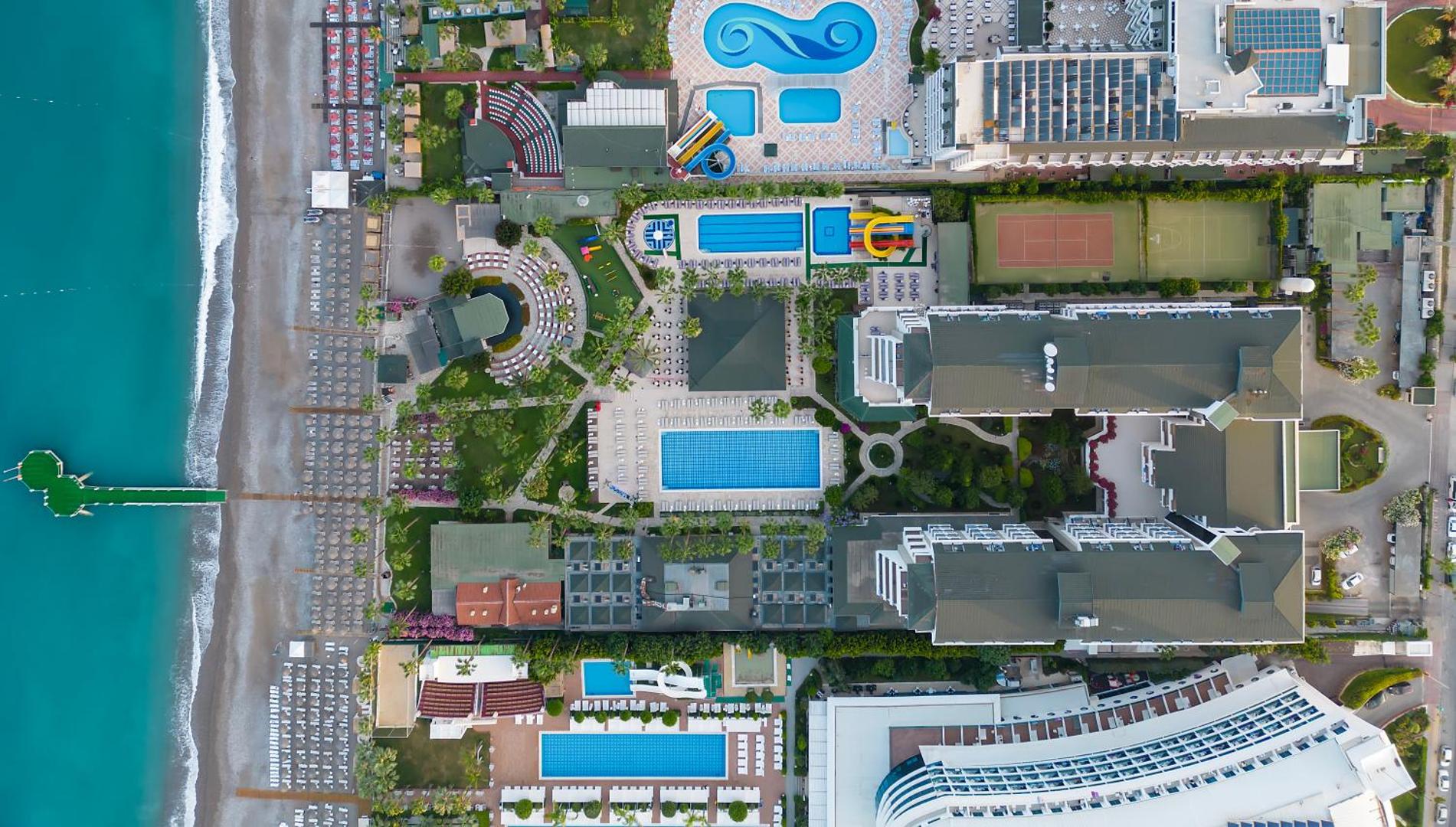 Meryan Hotel teritorijas plāns no augšas, parādot baseinus, ūdens slidkalniņus, tenisa kortus un tiešu pieeju jūrai
