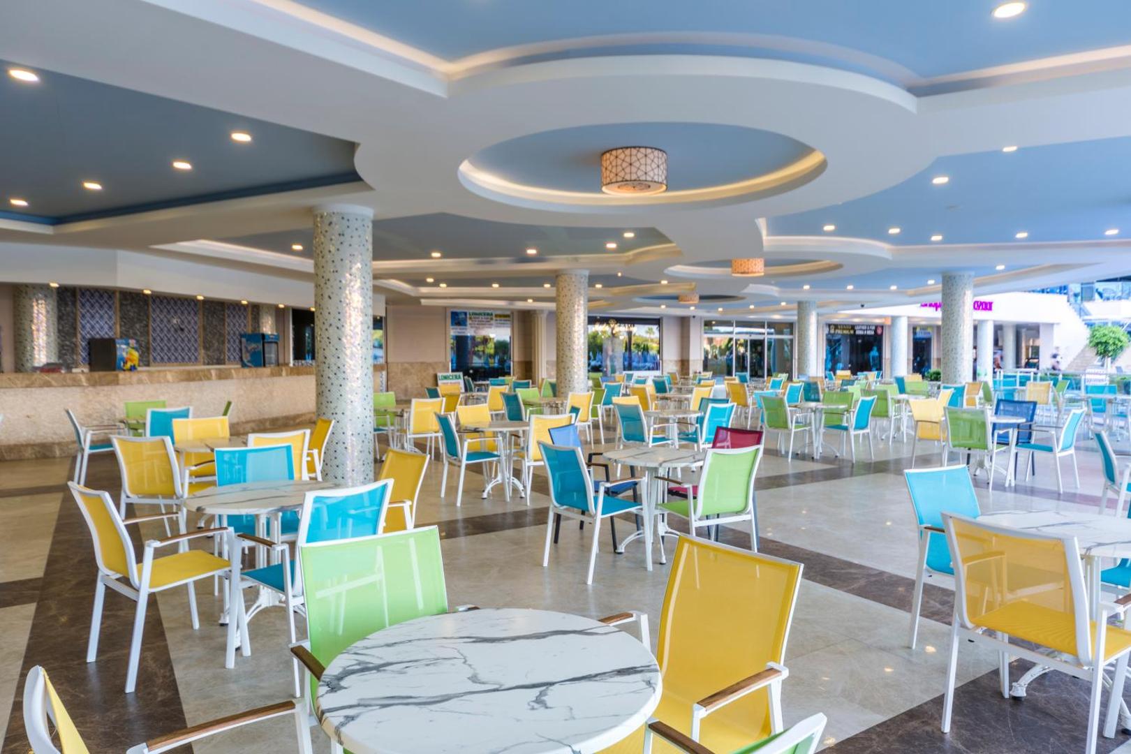 Moderns un krāsains Lonicera Resort & Spa Hotel atpūtas bārs ar dzelteniem un ziliem krēsliem plašā, gaišā iekštelpā