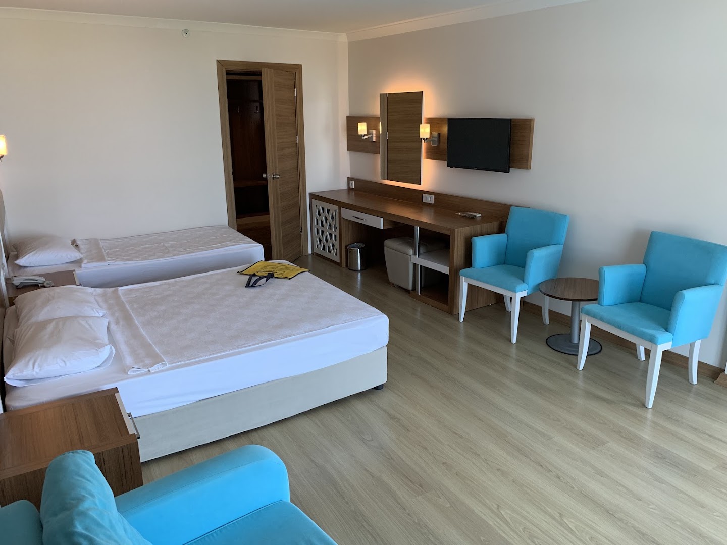 Lonicera Resort & Spa Hotel numura iekārtojums ar darba zonu, TV, tirkīza atpūtas krēsliem un lamināta grīdu