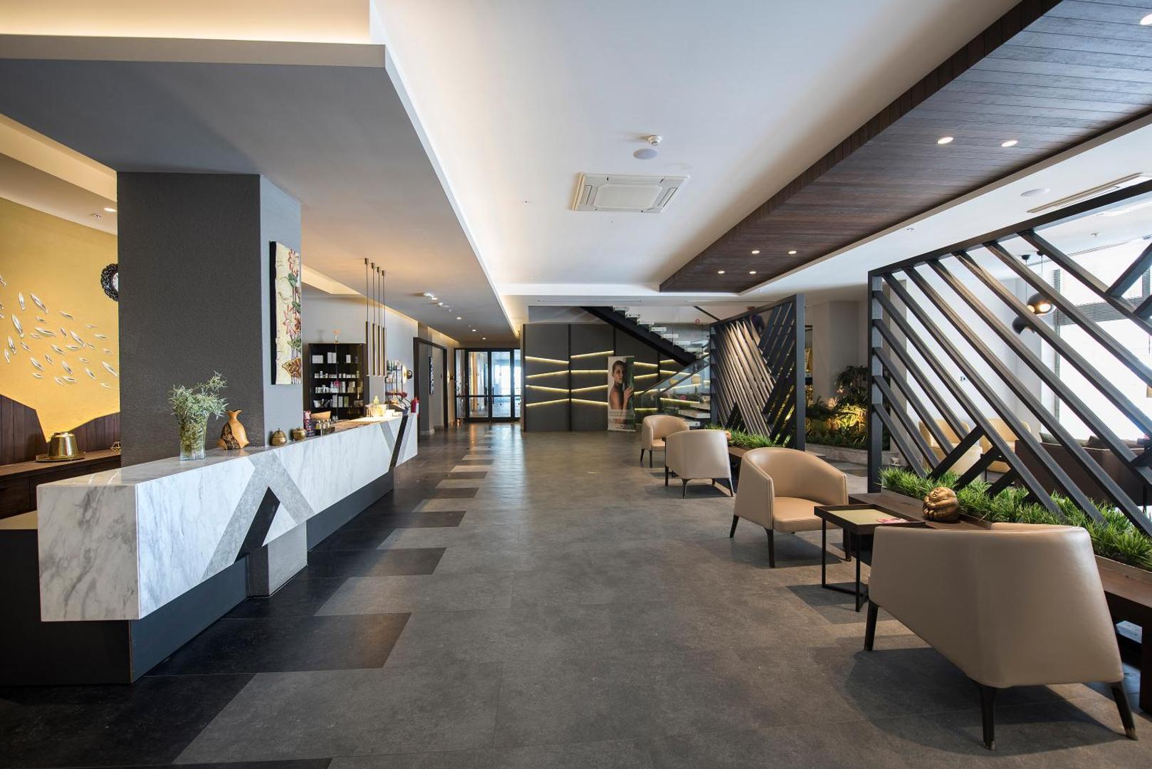 Akra Kemer modernā spa centra recepcija un atpūtas zona ar ērtiem krēsliem un elegantu dizainu