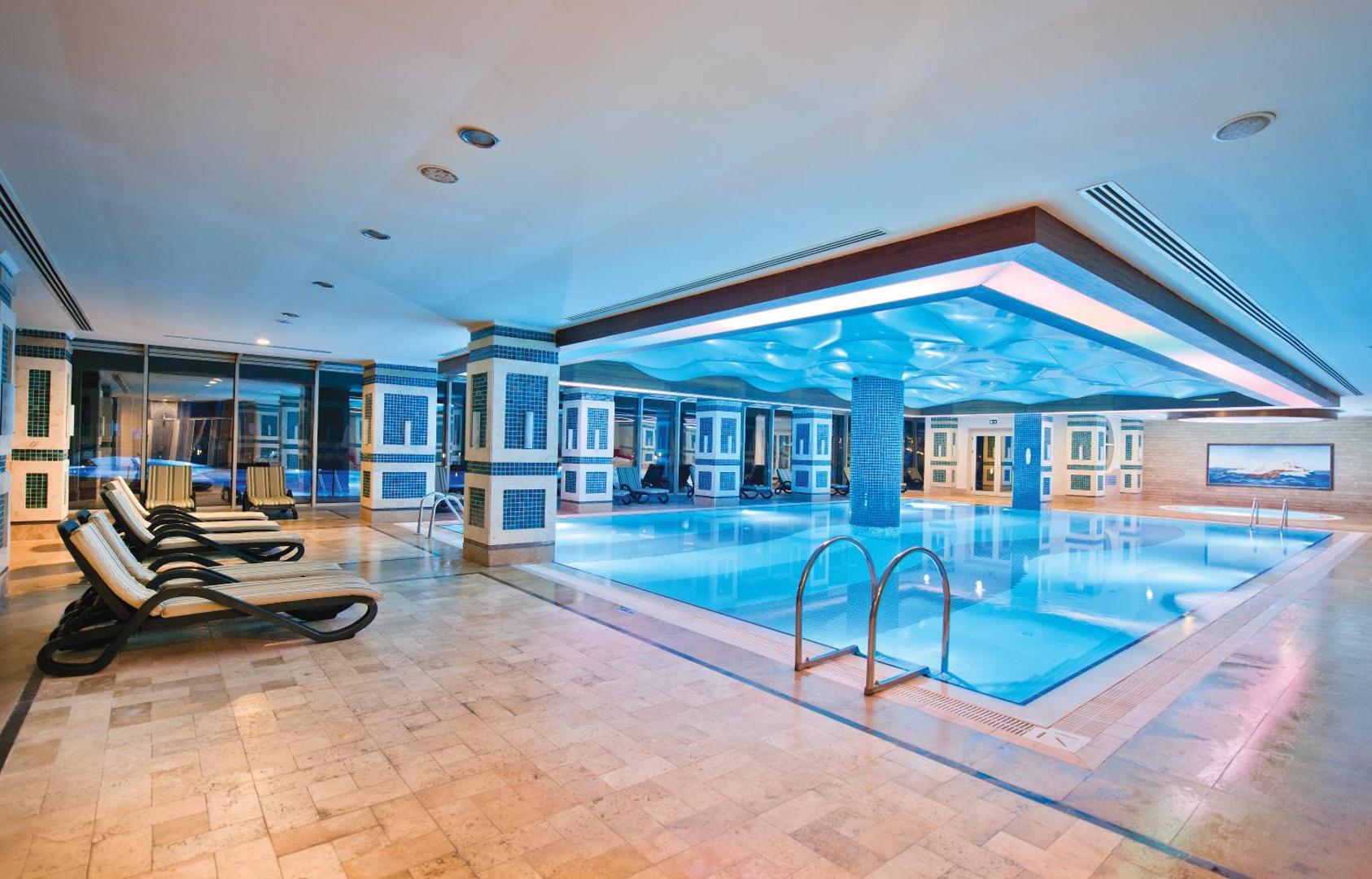 Sentido Kamelya Selin Luxury Resort & SPA iekštelpu spa baseins ar atpūtas krēsliem un dekoratīvu griestu apgaismojumu