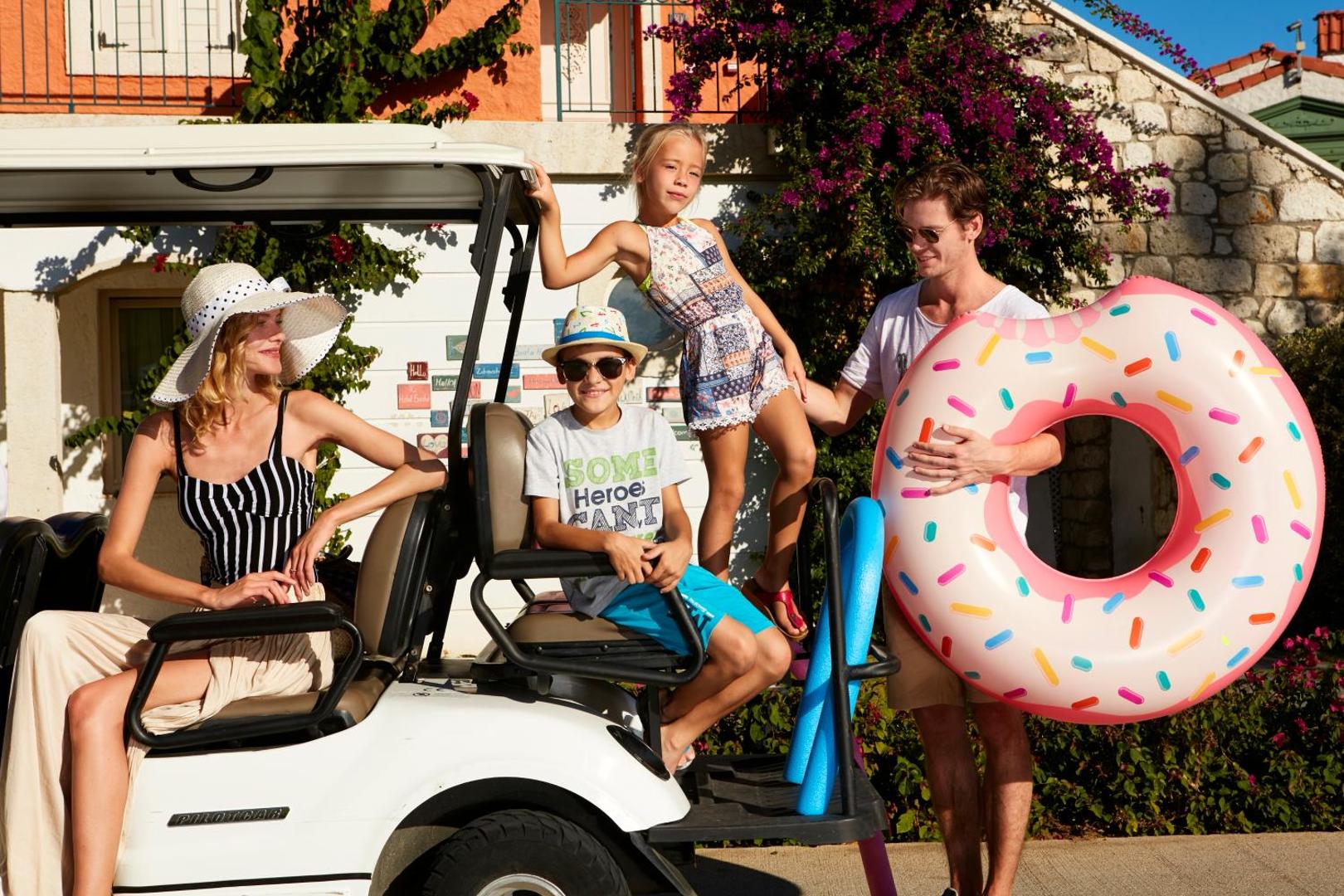 Ģimene ar bērniem pie IC Hotels Santai Family Resort golfa mašīnas Belekā, Turcijā – saulains rīts un gatavošanās atpūtai