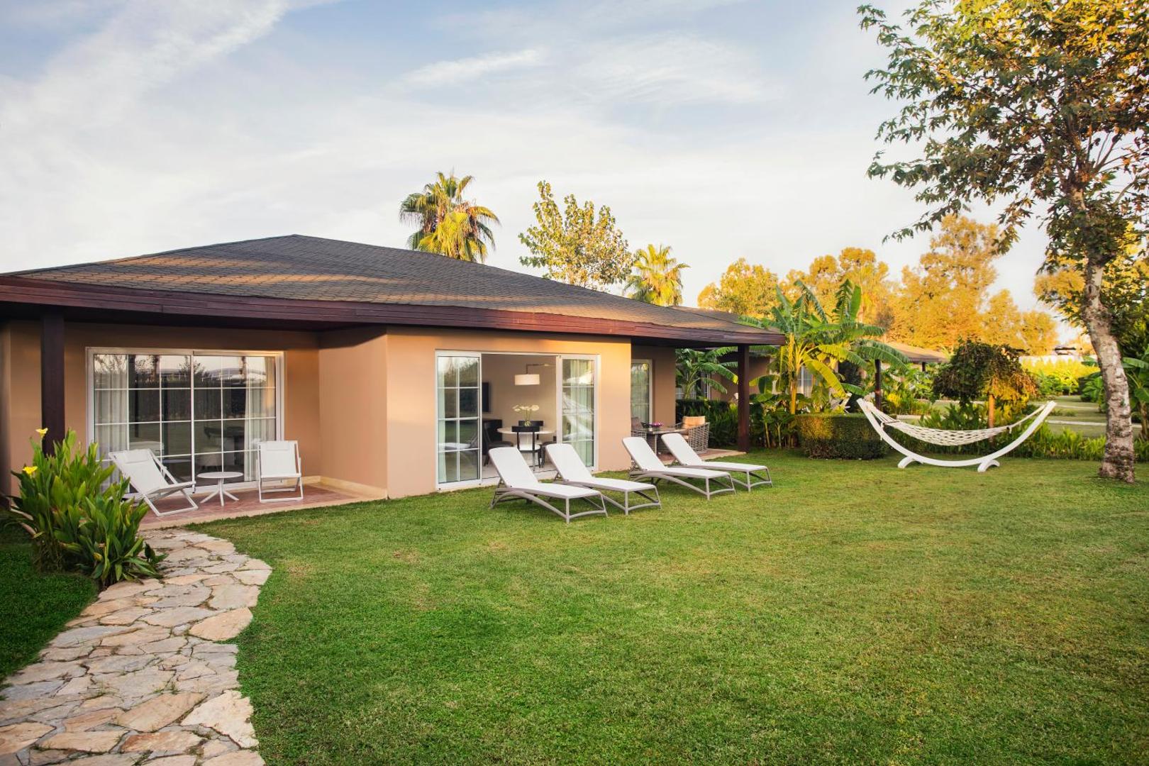 IC Hotels Santai Family Resort vienstāva bungalo ar privātu zālāju, sauļošanās krēsliem un šūpuļtīklu dārzā