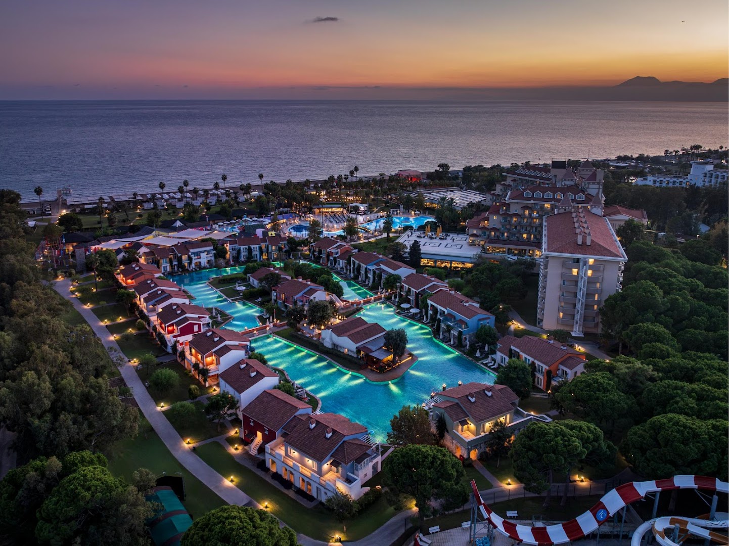 Aerofoto skats uz IC Hotels Santai Family Resort saulrieta laikā — redzama plašā teritorija, baseinu tīkls, pludmale un jūra