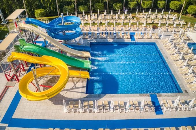 Grand Park Lara viesnīcas akvaparks ar četriem krāsainiem ūdens slidkalniņiem un plašu sauļošanās zonu Antalijā, Turcijā