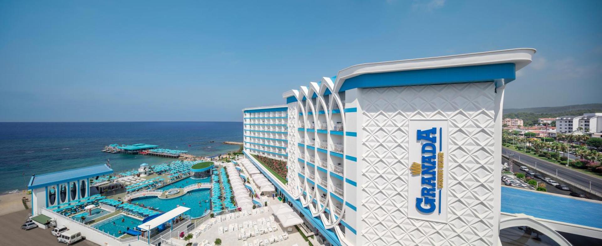 Granada Luxury Beach panorāmas skats uz baseinu zonu, viesnīcas korpusu un jūras piekrasti Alanjā no augšas dienas laikā