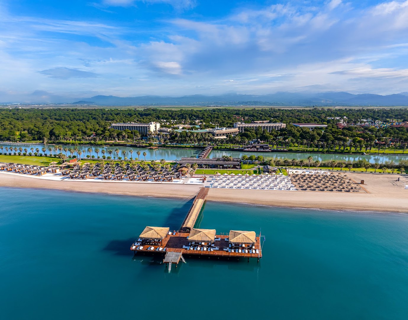 Gloria Serenity Resort pludmales zona ar saulessargiem, koka laipu un piestātni tirkīzzila ūdens piekrastē Belekā