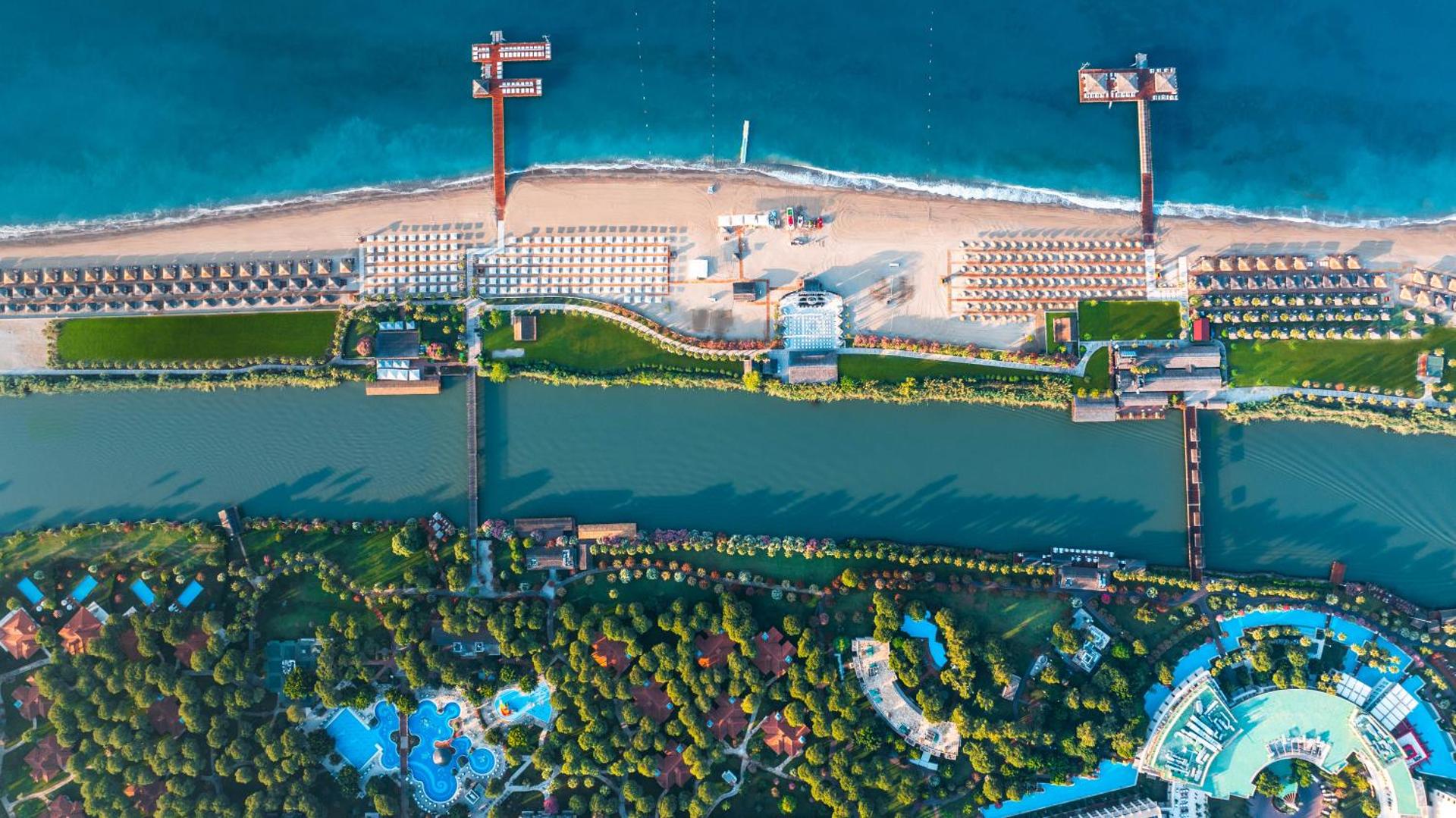 Gloria Serenity Resort aerofoto skats uz pludmali, upi un viesnīcas dārziem ar baseiniem un bungalo Belekas reģionā