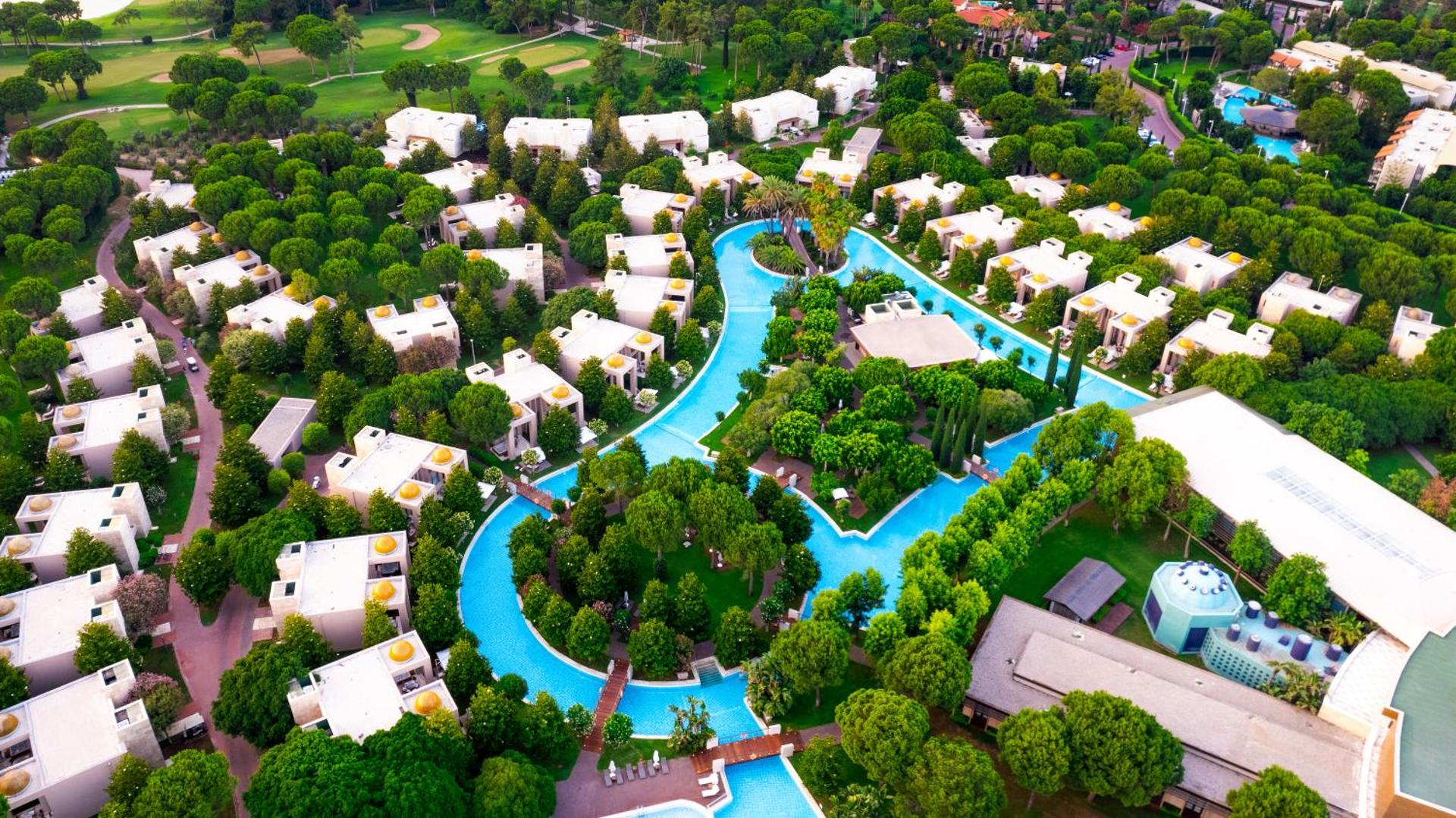 Gloria Serenity Resort Belekā no putna lidojuma — villas un bungalo tipa numuri starp priežu mežu un līkumotiem baseiniem