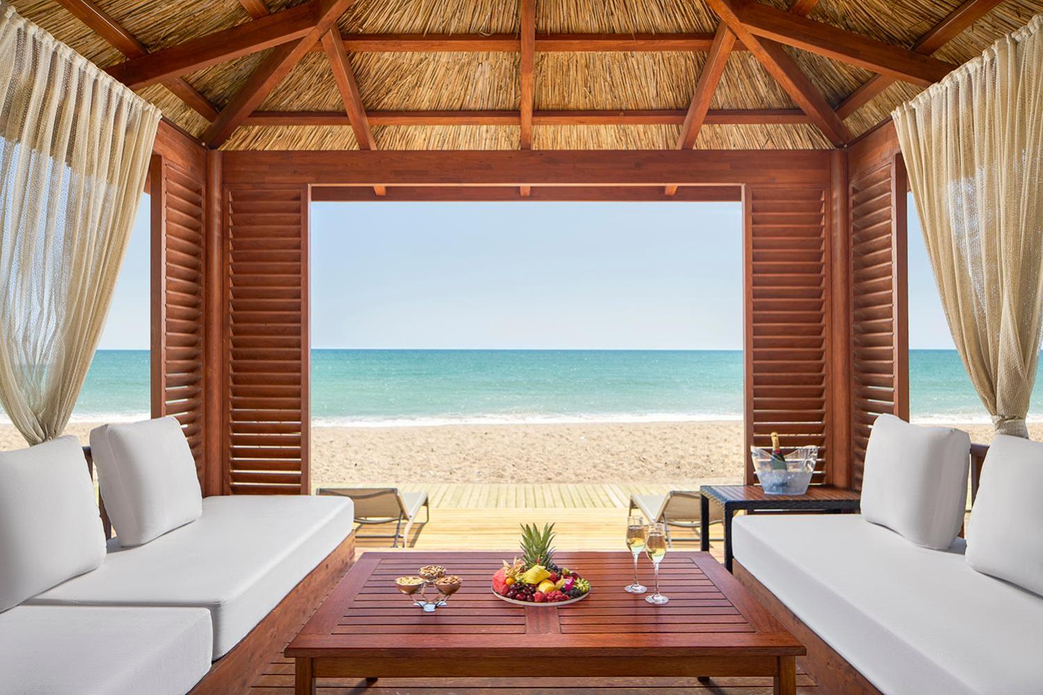 Gloria Serenity Resort privātais pludmales bungalo ar skatu uz jūru Belekā — koka terase ar dīvāniem, augļiem un dzērieniem