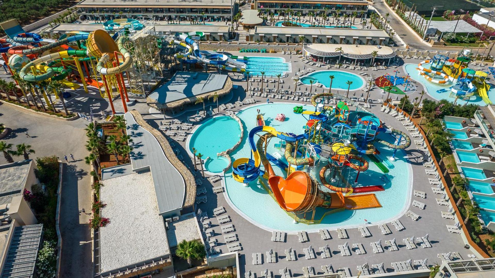 Stella Palace Aqua Park Resort plašais akvaparks no putna lidojuma ar krāsainiem slidkalniņiem, baseiniem un atpūtas zonām Krētā