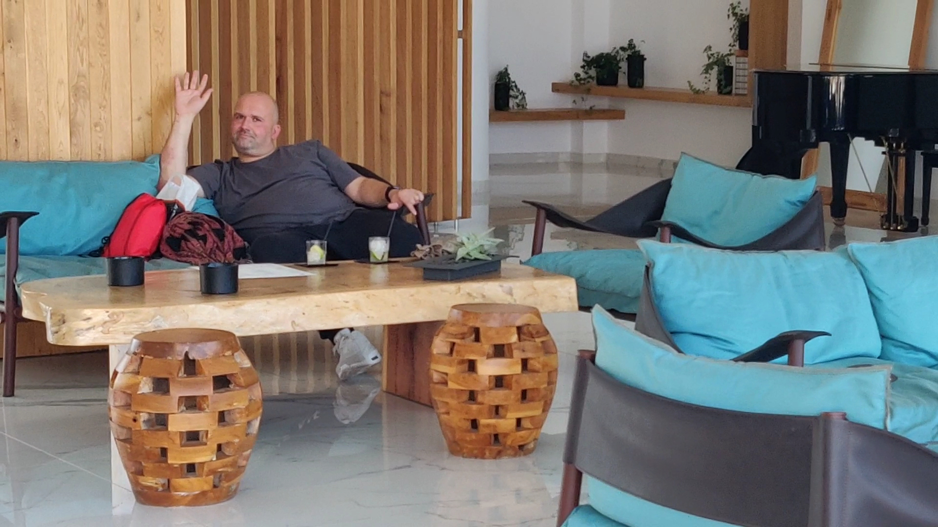 Stella Palace Aqua Park Resort lobby atpūtas zona ar gaiši ziliem dīvāniem, koka galdiņu un klavierēm fonā