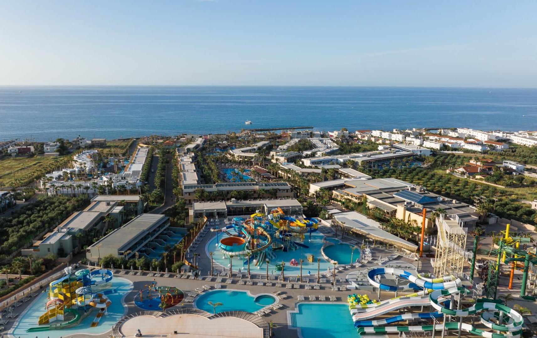 Stella Palace Aqua Park Resort plašā teritorija no putna lidojuma ar akvaparku, vairākiem baseiniem un skatu uz Vidusjūru
