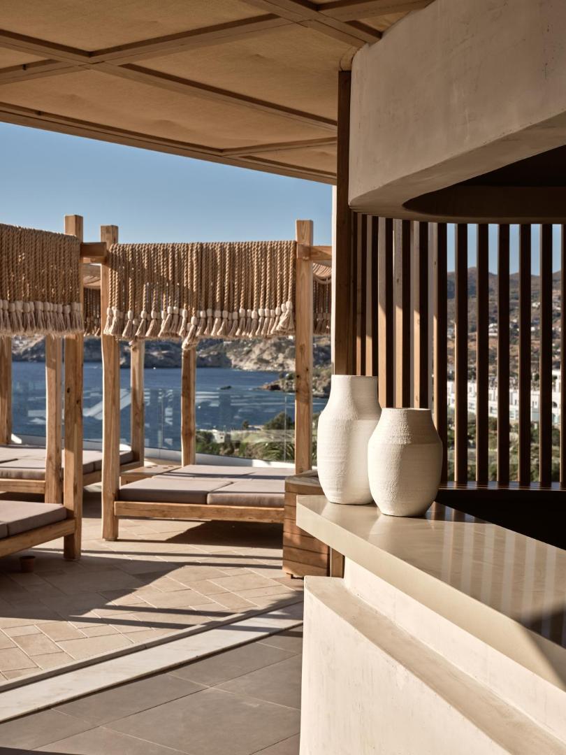 Seaside A Lifestyle Resort āra terase ar koka atpūtas gultām un skatu uz jūru Agia Pelagia piekrastē Krētā