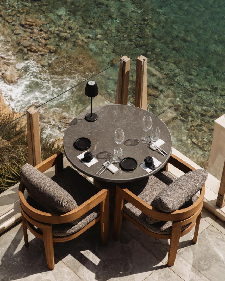 Seaside A Lifestyle Resort restorāna galdiņš divām personām uz terases tieši virs dzidra jūras ūdens piekrastē