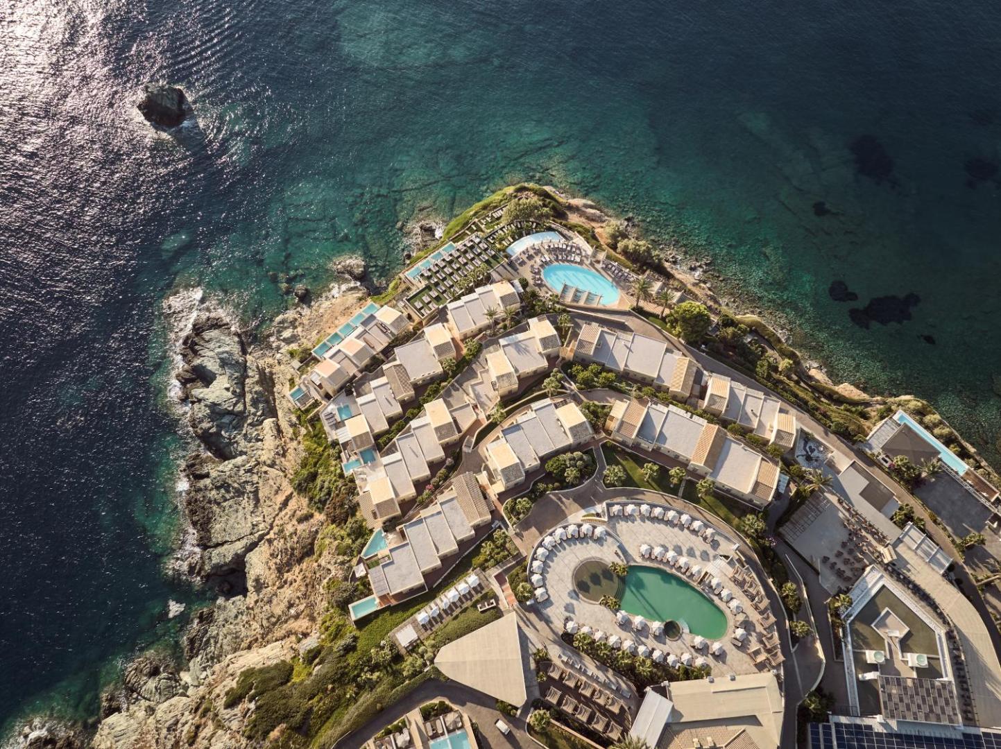 Seaside A Lifestyle Resort aerofoto skats uz galveno baseinu un sauļošanās terasēm Krētas piekrastē saulrietā